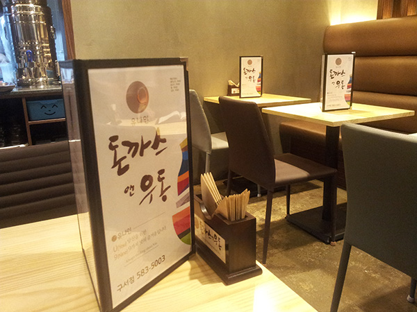 테이블 위 메뉴판과 수저통 디테일